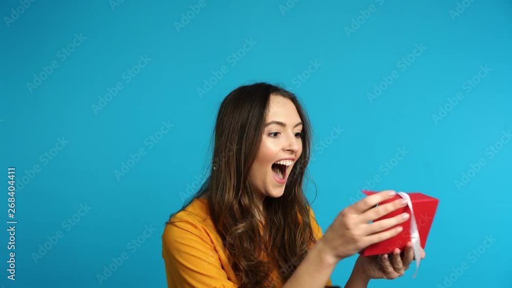Young happy woman opening gift card, she is excited and surprised Young happy woman opening gift card, she is excited and surprised