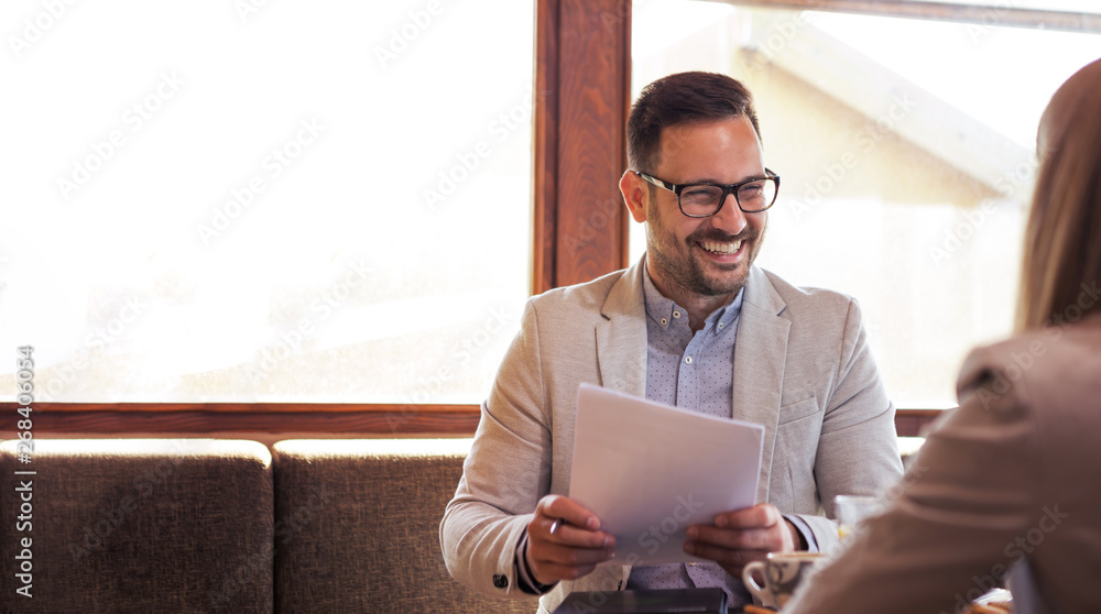 Young bearded handsome businessman with glasses is very pleased because in his hands he keeps very good results of his company's business. Young bearded handsome businessman with glasses is very pleased because in his hands he keeps very good results of his company's business.