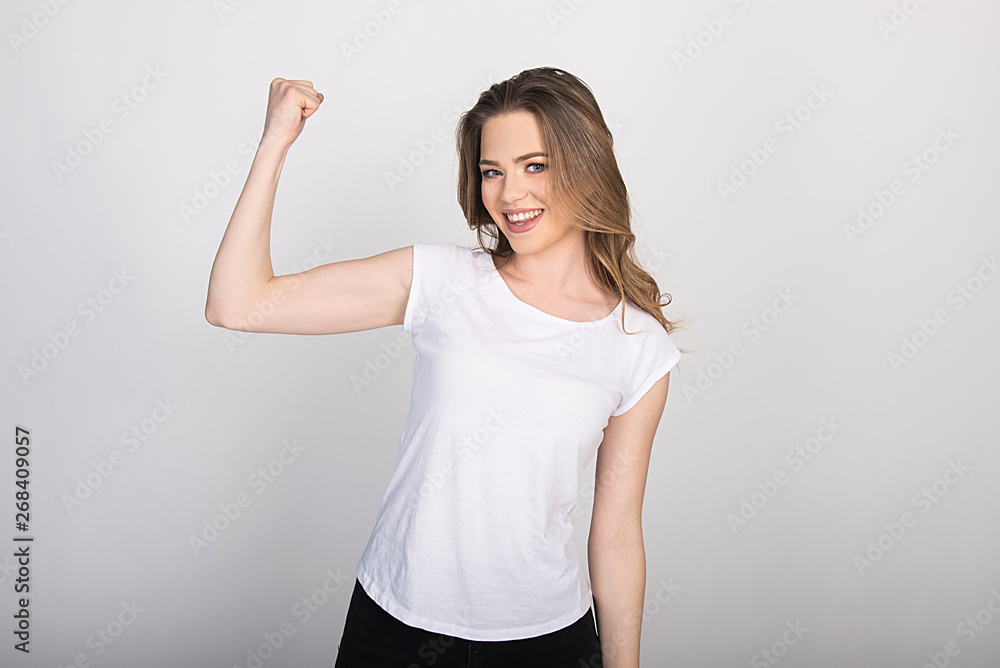 girl showing her biceps smiling beautiful model, girl power concept, isolated on white girl showing her biceps smiling beautiful model, girl power concept, isolated on white