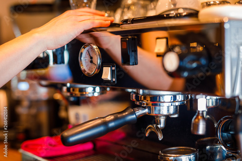 modern professional metal italian coffee machine with analog steam pressure gauge and female hand