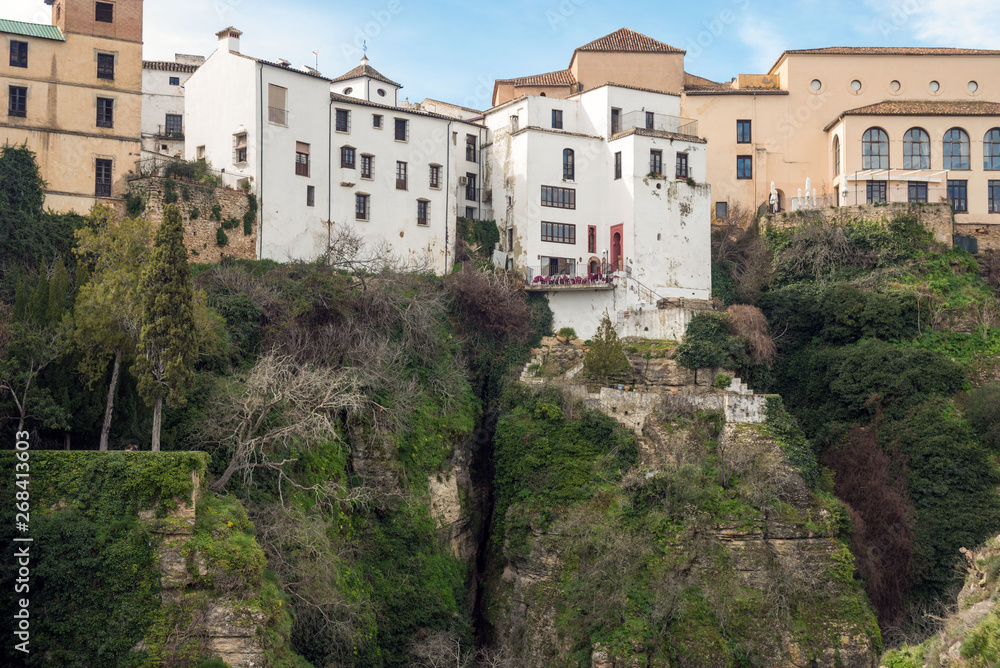 Residential buildings in the Spanish city of Ronda. Houses above the gorge of El Tajo. City over the abyss.