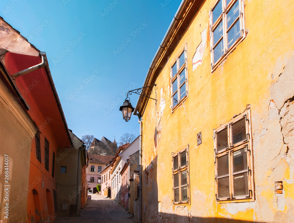Old colorful houses in Sighisoara citadel on a sunny spring morning. View towards the Church on the Hill