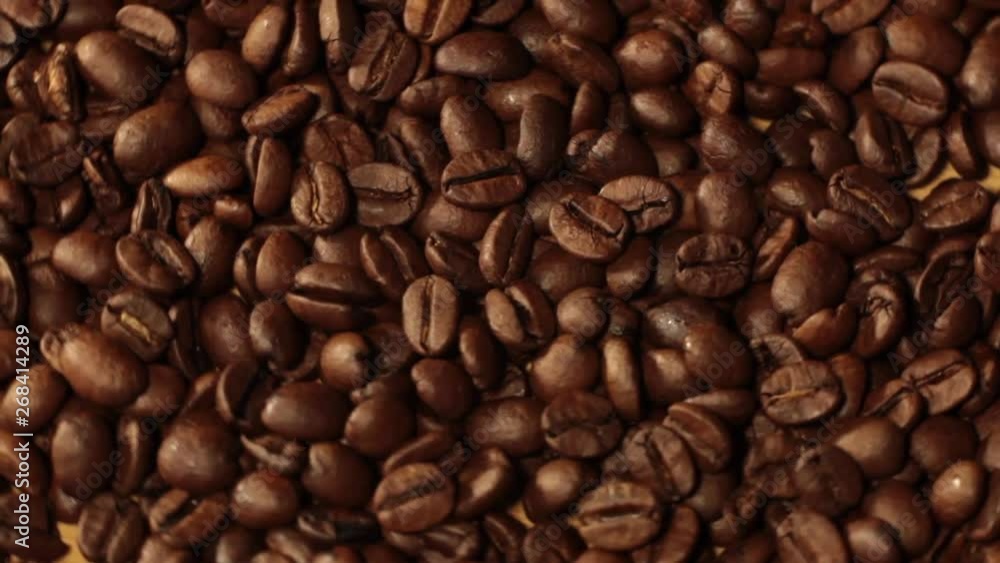 Dark Coffee Grains. Rotating and falling. Coffee beans. Close up of seeds of coffee. Beautiful seeds of coffee. Dark Coffee Grains. Rotating and falling. Coffee beans. Close up of seeds of coffee. Beautiful seeds of coffee.
