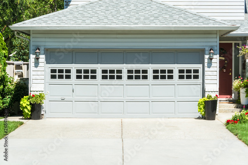 Canvas Print Wide garage door of residential house and concrete driveway in front