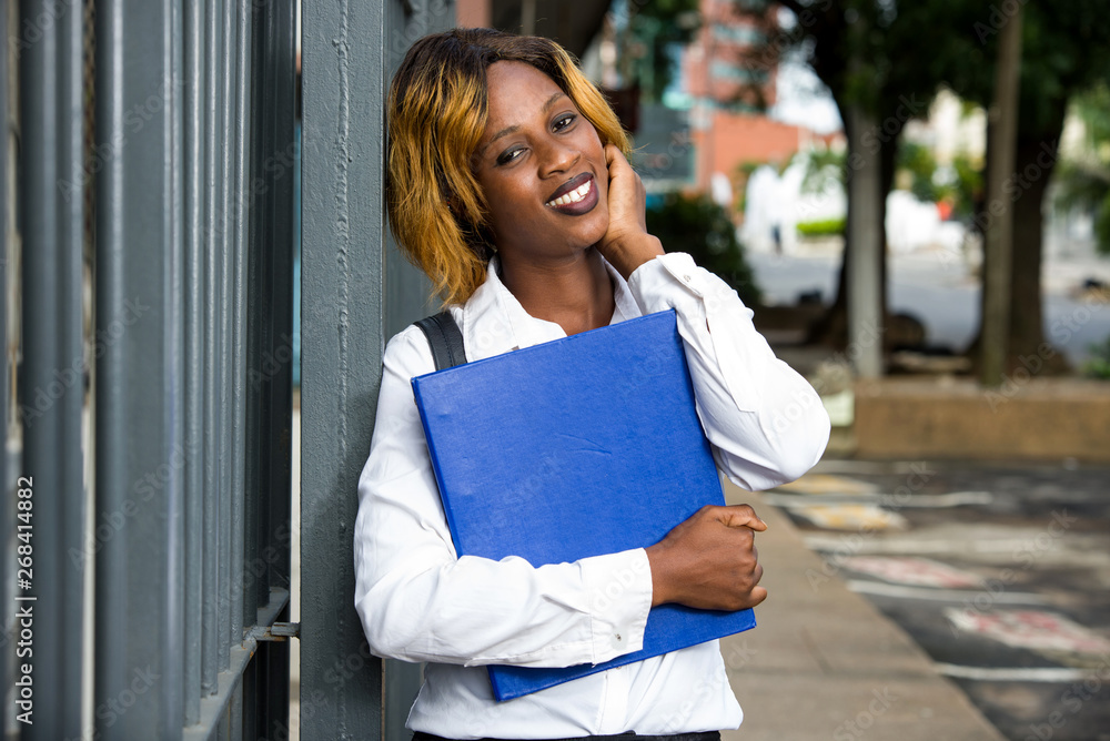 Portrait of smiling university student standing outside on the road to class Portrait of smiling university student standing outside on the road to class