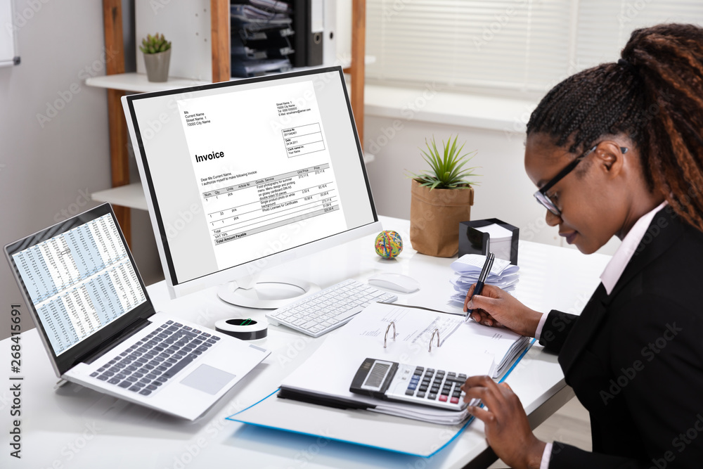 Fototapeta premium Businesswoman Using Calculator Calculating Invoice