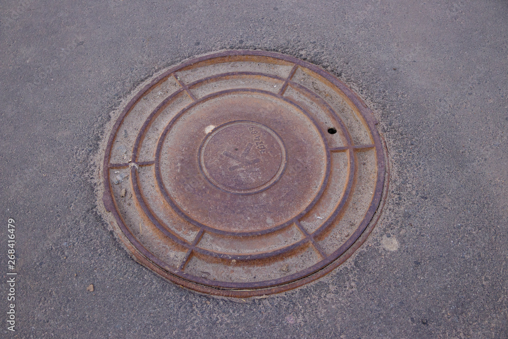 the round cover of the drain well that is on the road