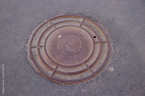 the round cover of the drain well that is on the road