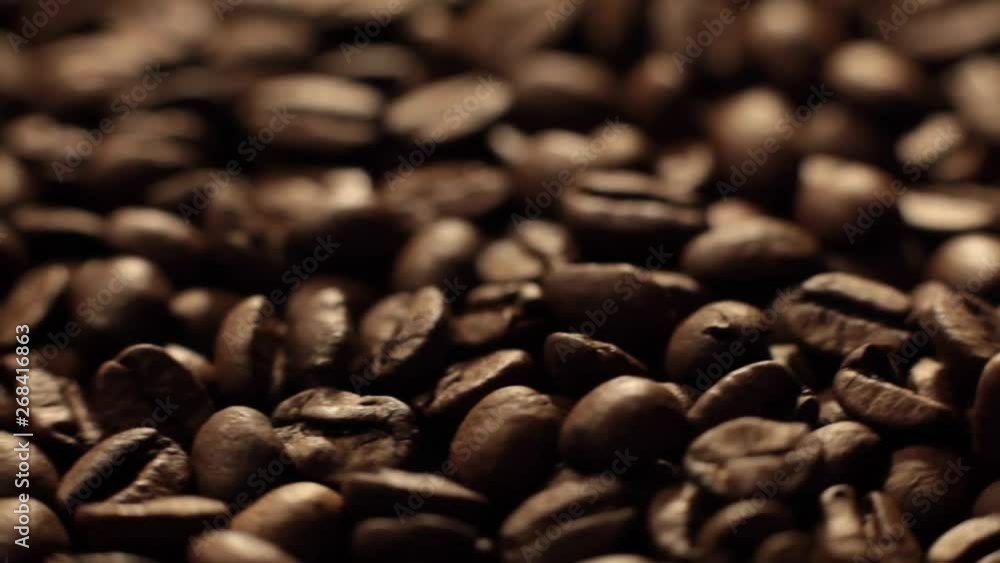 Beans factory mixing, close up. Roasted coffee bean. Beans of Coffee Raining at Slow Motion. Morning black coffee texture. Macro shot of coffee beans rotating along its axis. Beans factory mixing, close up. Roasted coffee bean. Beans of Coffee Raining at Slow Motion. Morning black coffee texture. Macro shot of coffee beans rotating along its axis.