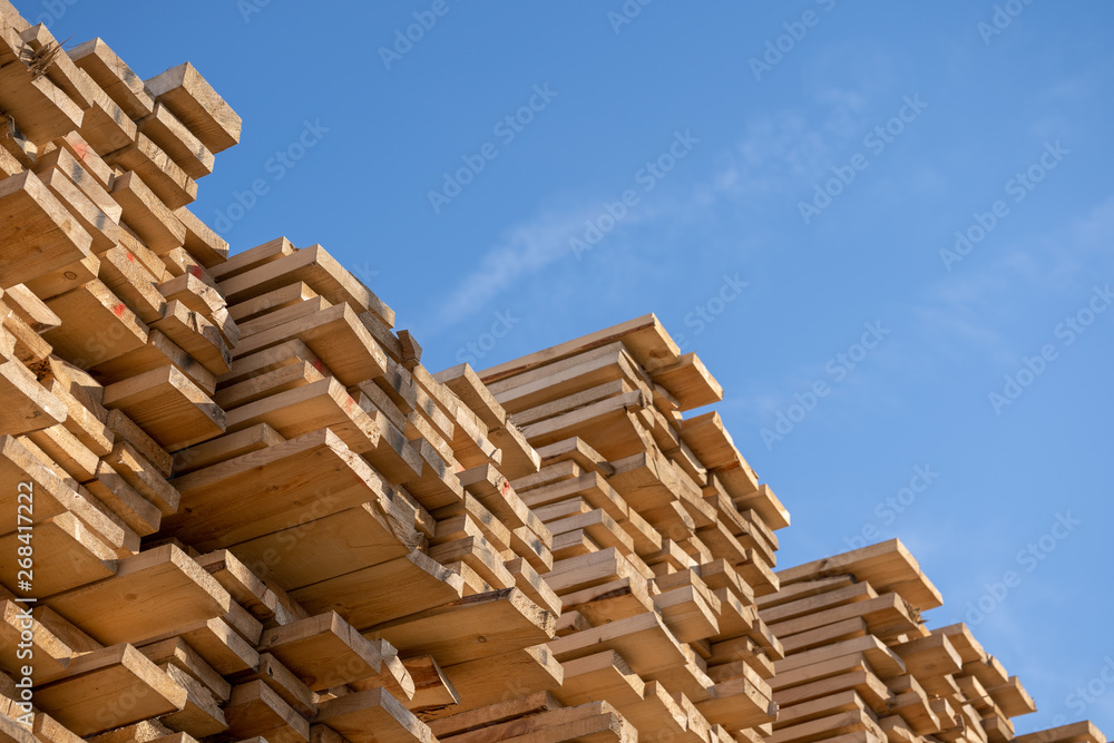 Wooden boards, lumber, industrial wood, timber. Pine wood timber stack of natural rough wooden boards on building site. Industrial timber building materials Wooden boards, lumber, industrial wood, timber. Pine wood timber stack of natural rough wooden boards on building site. Industrial timber building materials