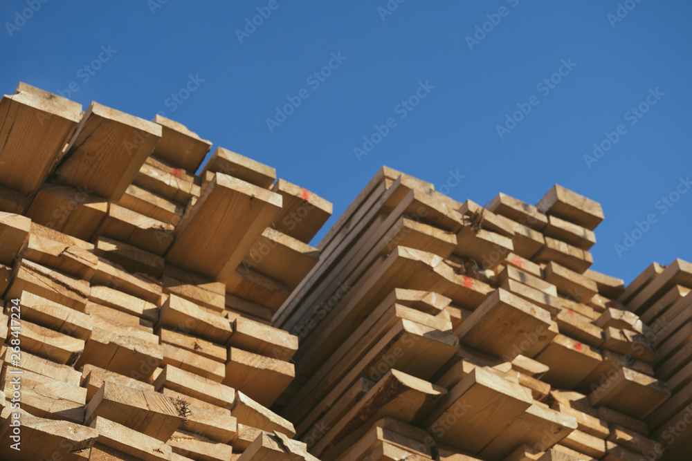 Wooden boards, lumber, industrial wood, timber. Pine wood timber stack of natural rough wooden boards on building site. Industrial timber building materials Wooden boards, lumber, industrial wood, timber. Pine wood timber stack of natural rough wooden boards on building site. Industrial timber building materials