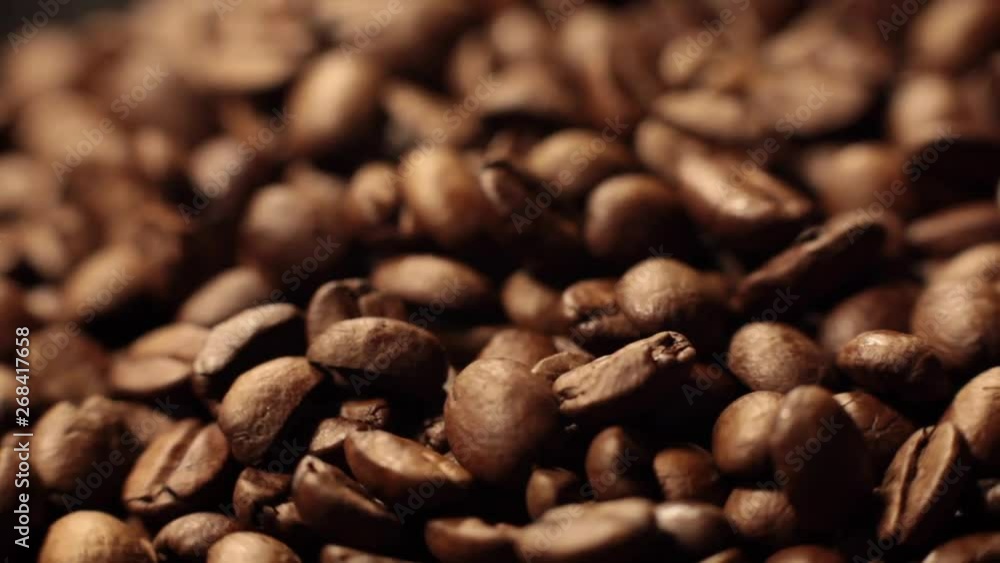 Beans factory mixing, close up. Roasted coffee bean. Beans of Coffee Raining at Slow Motion. Morning black coffee texture. Macro shot of coffee beans rotating along its axis. Beans factory mixing, close up. Roasted coffee bean. Beans of Coffee Raining at Slow Motion. Morning black coffee texture. Macro shot of coffee beans rotating along its axis.