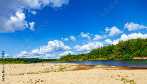 Wild sandy beach, only sand, river and thick clouds