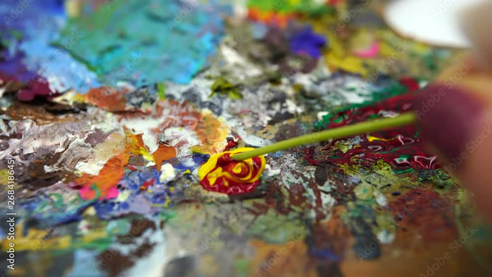 Amazing range of painting colors turning over. Mixed colors in oil. Different paints prepared on wooden pallete Amazing range of painting colors turning over. Mixed colors in oil. Different paints prepared on wooden pallete