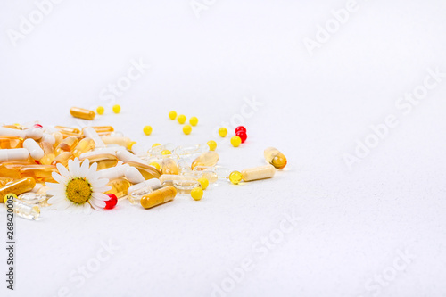 Scattered pills and vitamins on a white background. Health care and nutritional supplements.