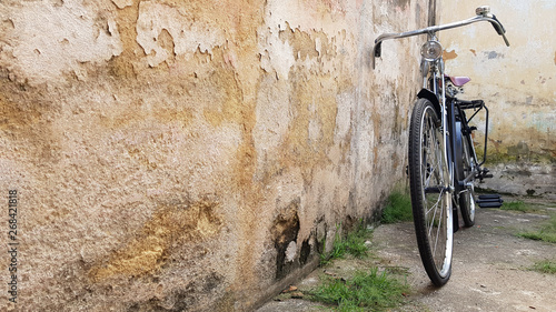 Retro vintage black bike on old brick wall.