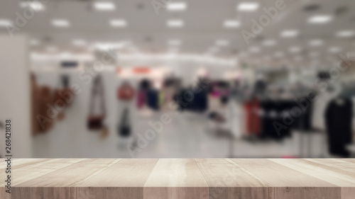 Empty wood table and blurred clothing store, product display montage
