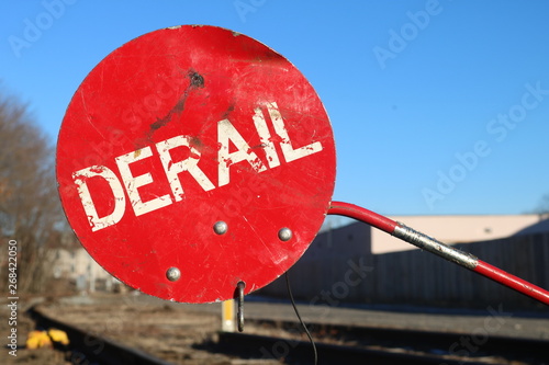 Red derail warning symbol sign on old abandoned railroad tracks  photo