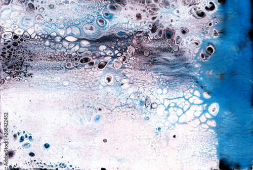 Very beautiful texture background. White paint flows in blue with the addition of black paint. Style includes curls of marble or agate with bubbles and cells. Natural style.