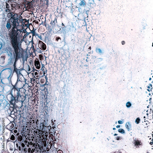 Very beautiful texture background. White paint flows in blue with the addition of black paint. Style includes curls of marble or agate with bubbles and cells. Natural style.