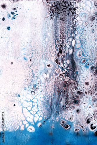 Very beautiful texture background. White paint flows in blue with the addition of black paint. Style includes curls of marble or agate with bubbles and cells. Natural style.