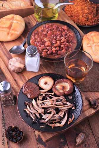 Edible mushrooms and red beans cooked on classic wooden board
