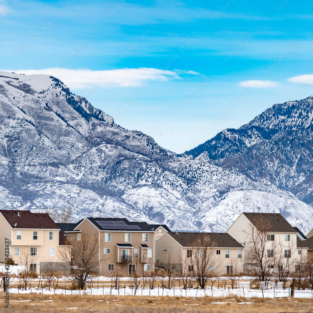 Clear Square Row of beautiful homes against a rugged mountain dusted with snow in winter