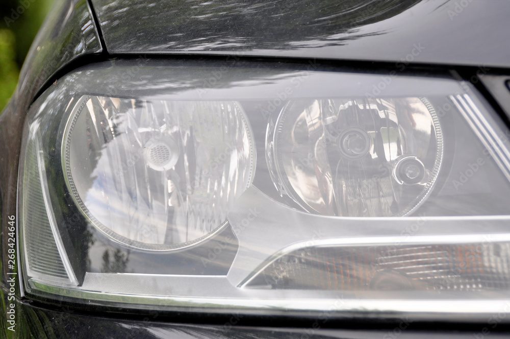 Car headlight. Clean car headlamp with water drops after washing. Exterior of modern car.