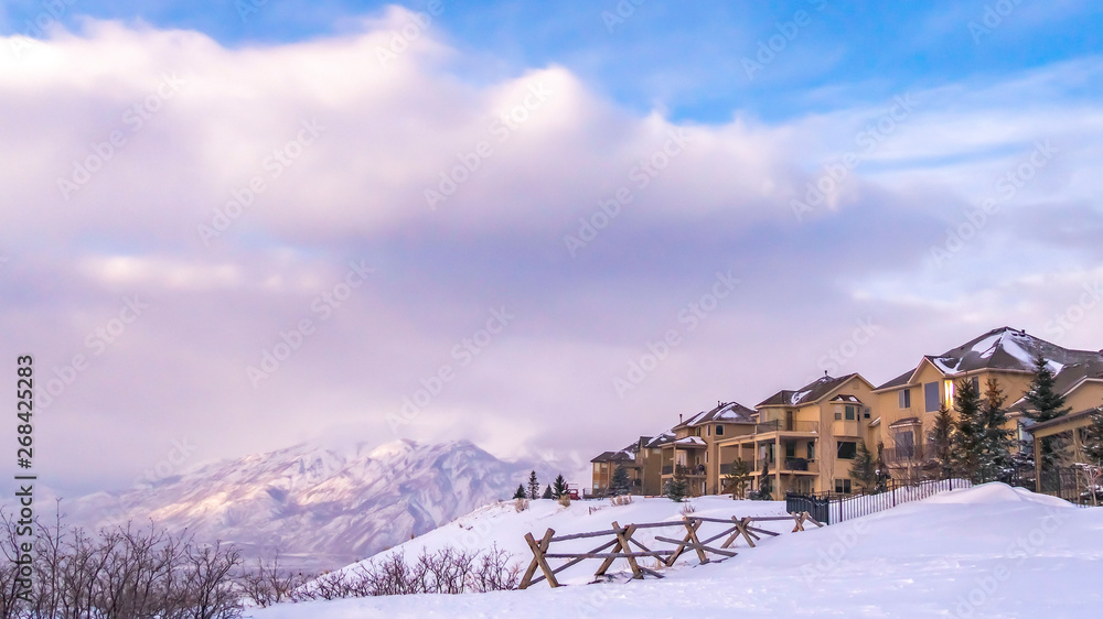 Clear Panorama Homes overlooking a scenic snow capped mountain and vivid blue sky with clouds