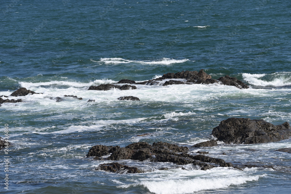 The scene of the beach. Waves crashing into rocks. The scene of the beach. Waves crashing into rocks.