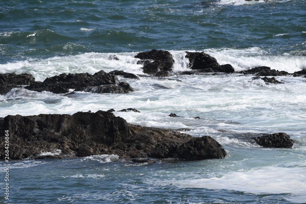 The scene of the beach. Waves crashing into rocks. The scene of the beach. Waves crashing into rocks.