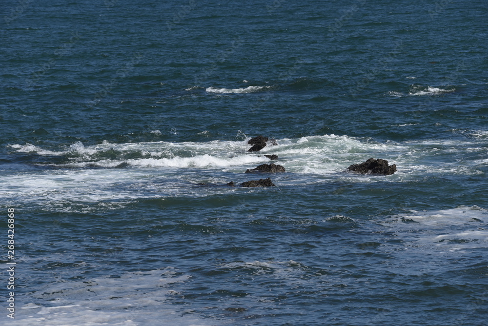 Fototapeta premium The scene of the beach. Waves crashing into rocks.