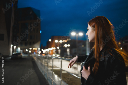 Stylish young woman standing in the night city. Dating, waiting, relaxing concept.