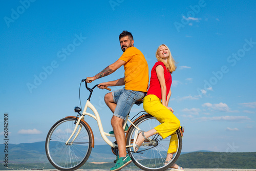 Beautiful summer day. Summer couple. Sexy couple in love. Couple in love riding a bike. Active people. Stylish and loving couple enjoying.