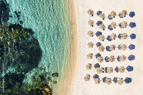 Obraz na płótnie View from above, stunning aerial view of a white beach with beach umbrellas and turquoise clear sea. Emerald Coast, Sardinia, Italy. w salonie