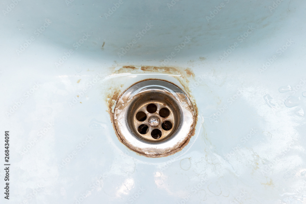 Dirty sink drain mesh, hole with limescale or lime scale and rust on it, dirty rusty bathroom washbowl Dirty sink drain mesh, hole with limescale or lime scale and rust on it, dirty rusty bathroom washbowl