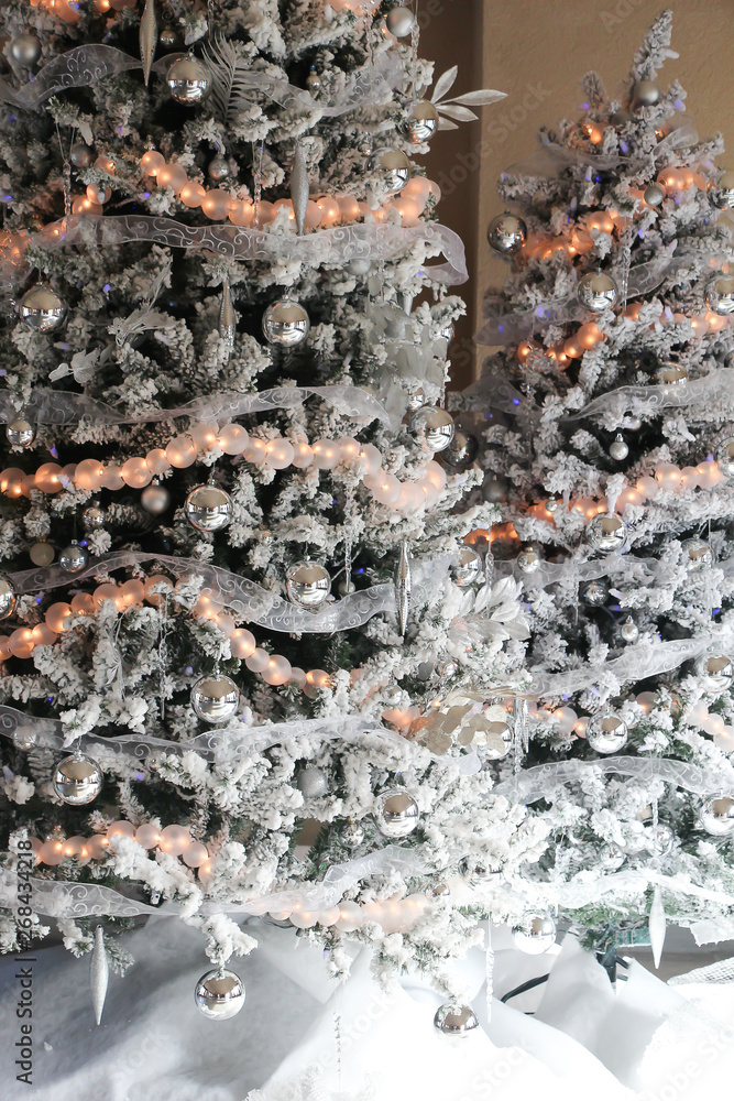 two beautifully decorated holiday trees in white and gold 