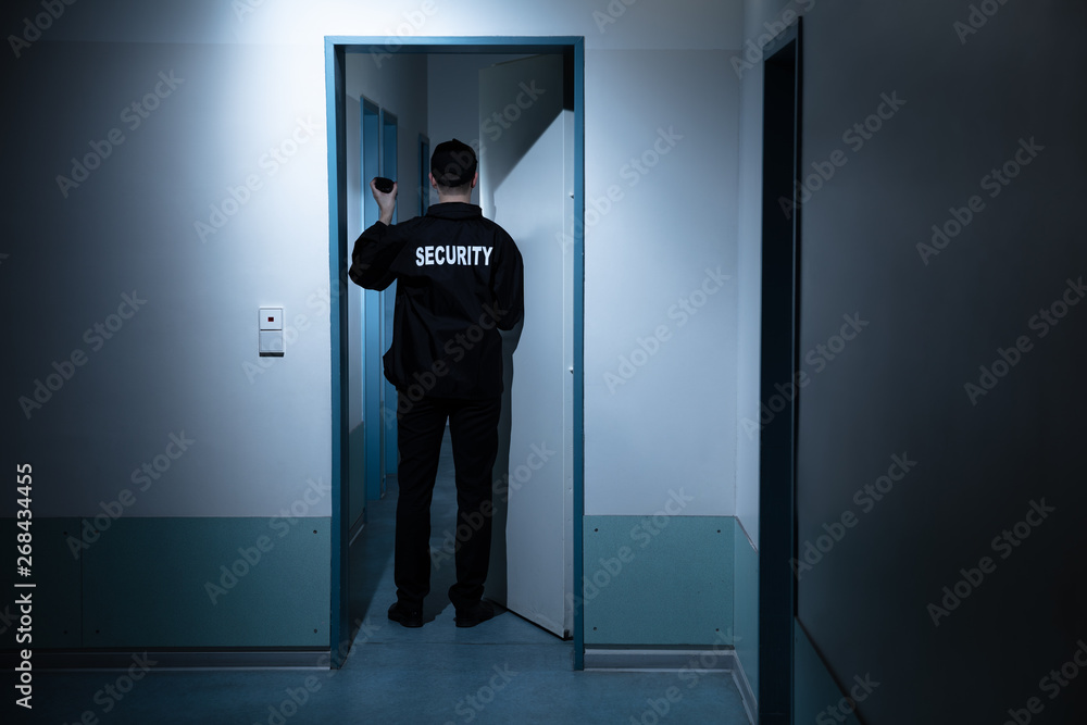 Security Guard Standing In Corridor Of Building