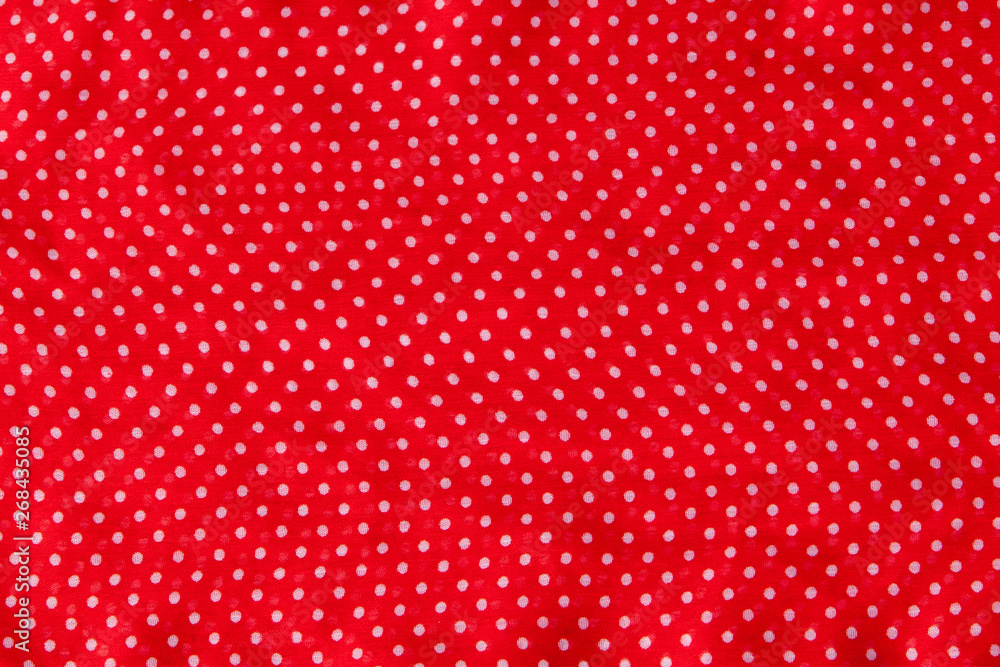 Red fabric with the white polka dots as a background texture composition