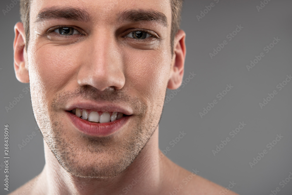 Obraz premium Handsome young man with stubble standing against blue-gray background
