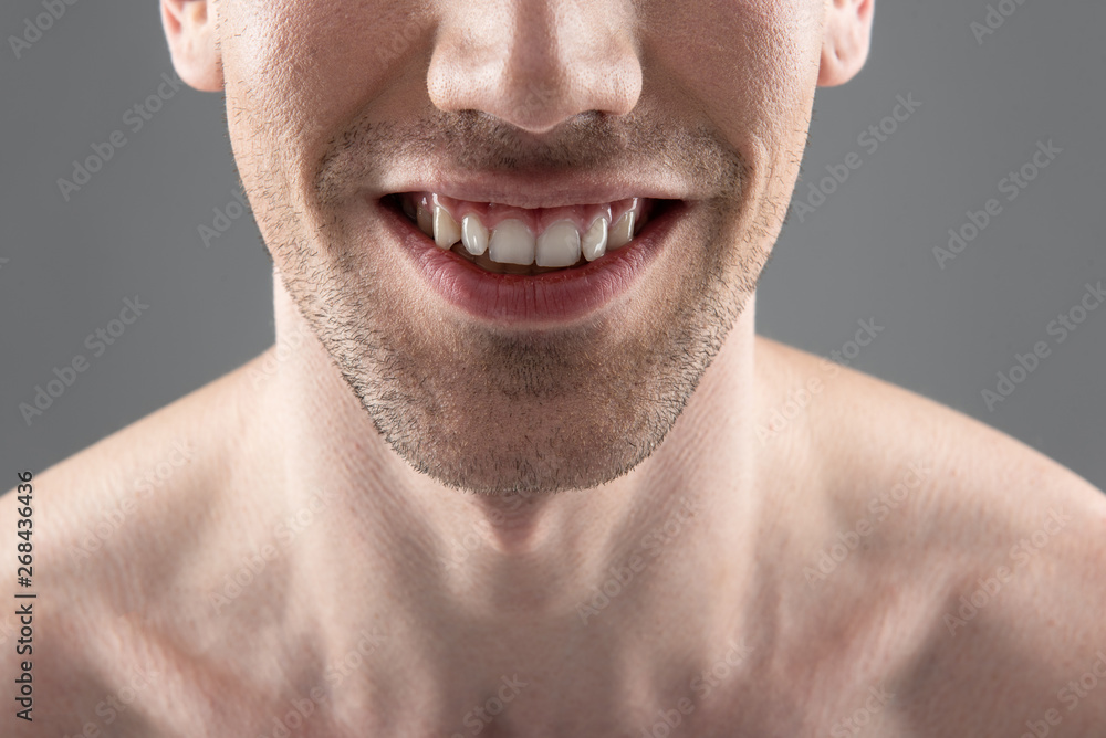 Obraz premium Young man smiling and demonstrating his white healthy teeth