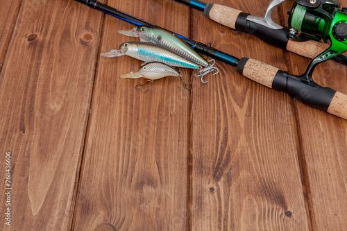 Fishing tackle - fishing spinning, hooks and lures on wooden background with copy space
