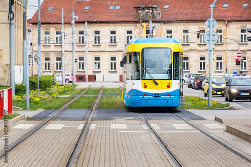 Colourful tram runs on tramway track over green grass area in Kosice (SLOVAKIA)