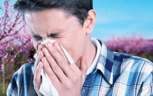 Young handsome man blowing his nose