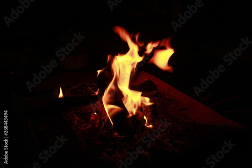 Glowing Yellow and orange colour fire is flamming and burning on a black background.Abstract design photo