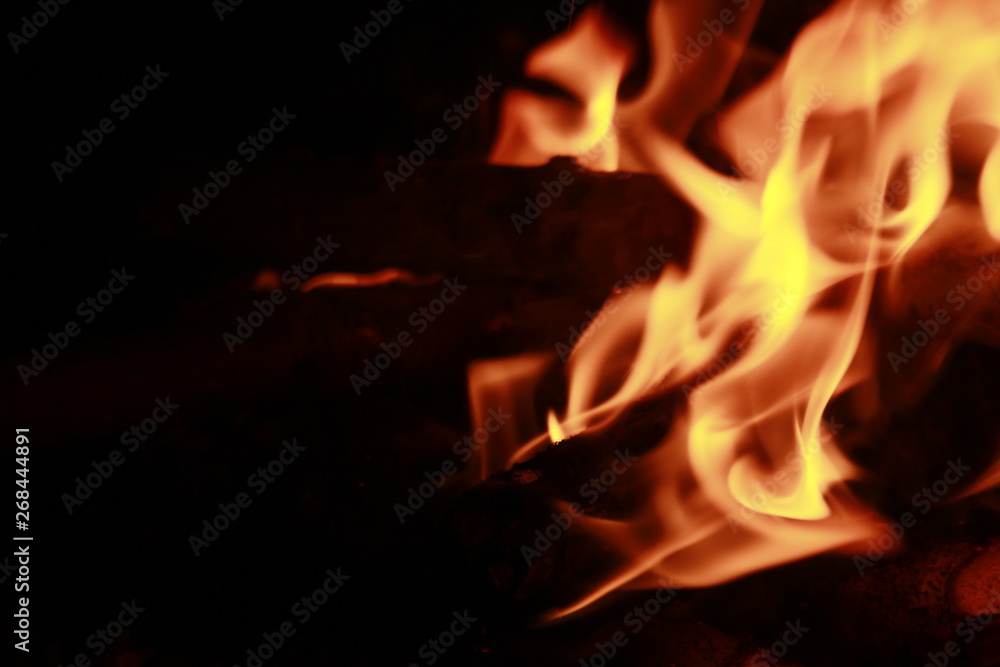 Glowing Yellow and orange colour fire is flamming and burning on a black background.Abstract design Glowing Yellow and orange colour fire is flamming and burning on a black background.Abstract design