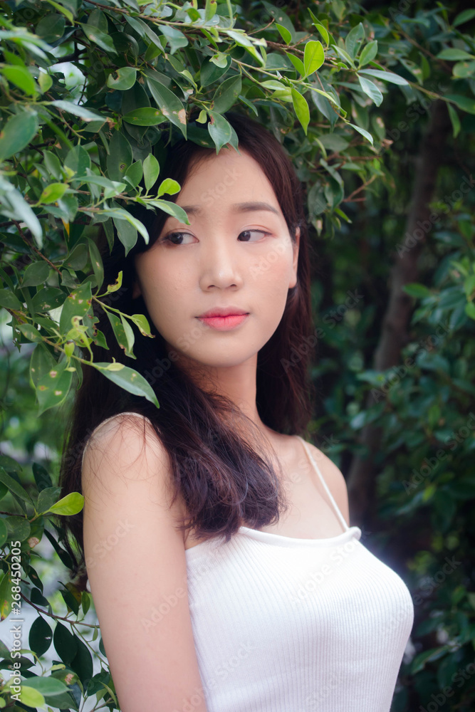 Portrait of thai china adult beautiful girl White shirt blue jeans relax and smile Portrait of thai china adult beautiful girl White shirt blue jeans relax and smile