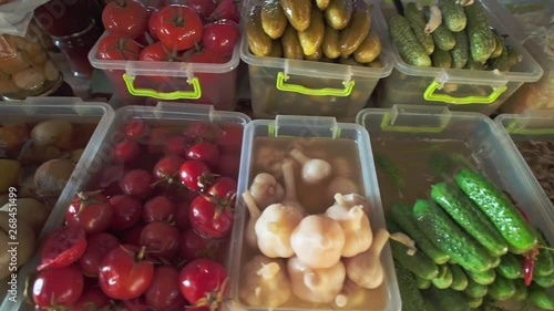 Assortment of pickles, mushrooms, tomatoes, onions and other salting on local food market of healthy food photo