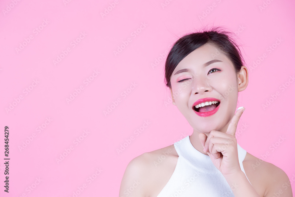 Beautiful woman with cream on the skin on a pink background. Beautiful woman with cream on the skin on a pink background.