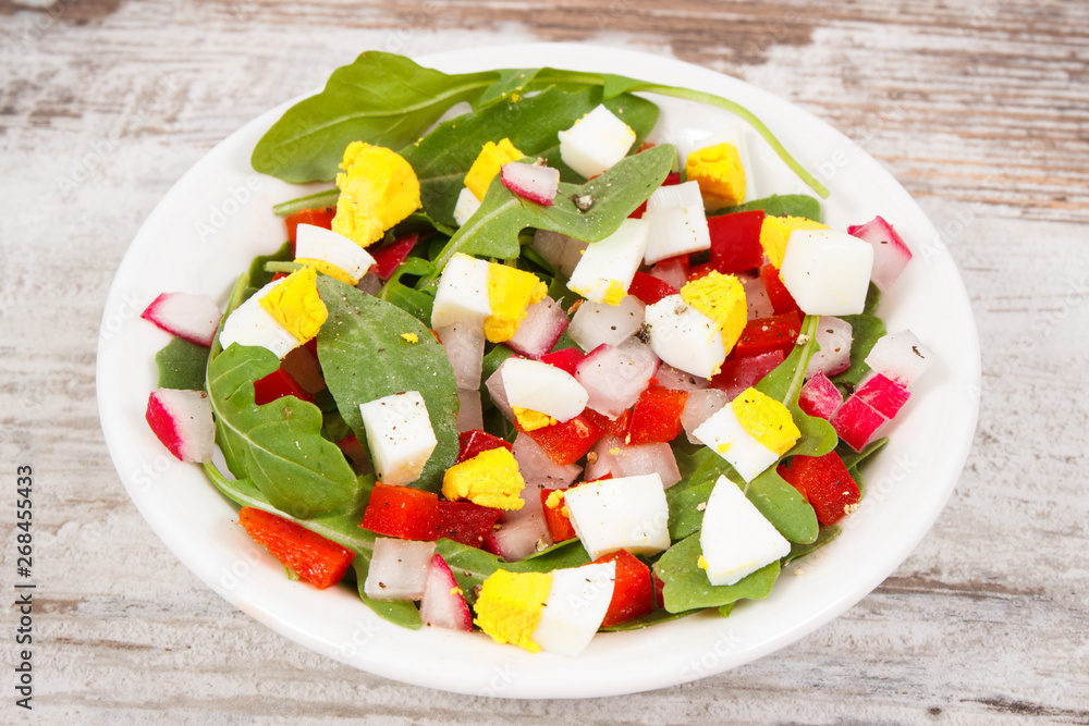 Fresh prepared salad with eggs and vegetables in bowl, healthy nutrition concept